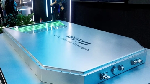 Large silver CATL Shenxing Battery III pack on display under green stage lighting at an industry event